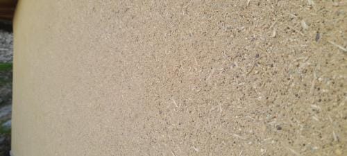 Nakanuri (Enduit intermédiaire) en terre, paille de riz et sables. Structure en bauge avec sous bassement en pierres hourdées à la terre. Vu de près. Lavé par les éléments.